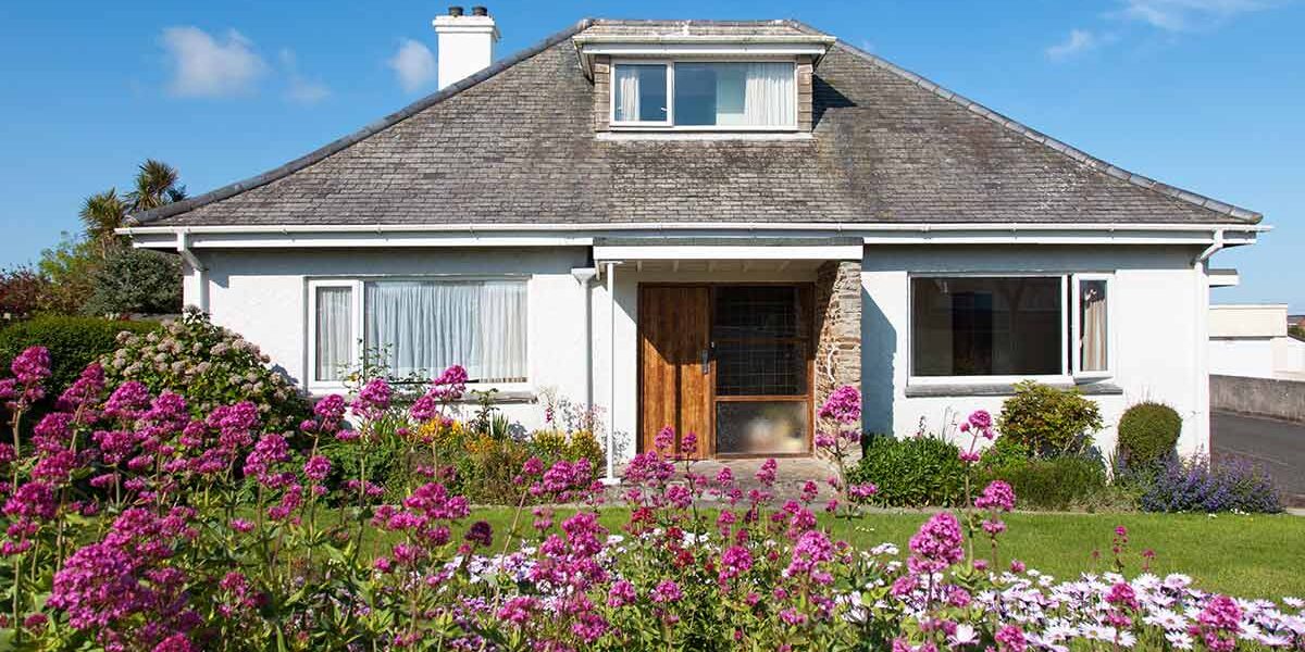 Ein Bungalow mit grünem Garten und blauem Himmel | Immobilienbewertung